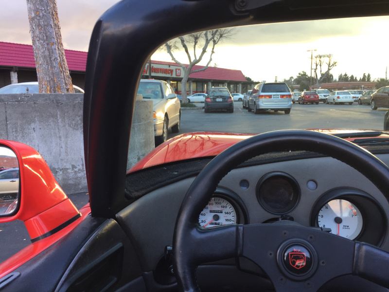 A pure, beautiful steering wheel and a dashboard completely done in hard plastic. There is no trim on that A-pillar. Just painted metal.